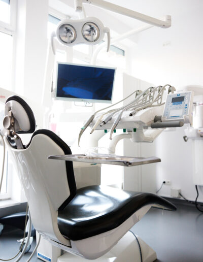 Fotel zabiegowy w nowoczesnym gabinecie stomatologicznym gotowy do przyjęcia pacjenta.