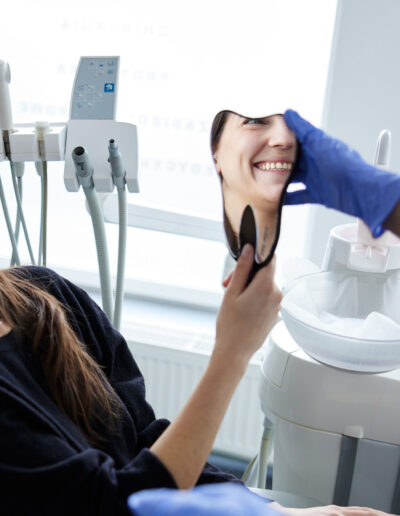 usmiechnieta pacjentka z nowym zdrowym usmiechem